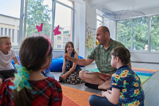 A special education teacher leading a small-group discussion with students in a bright classroom